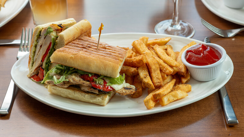 Grilled chicken panini sandwich with side of french fries